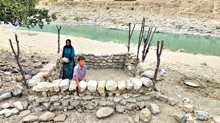 Nomadic Survival: Orphan Boy and Mother Build Stone Shelter by the Raging River