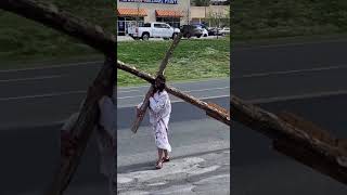 Jesus walking on roadside with cross