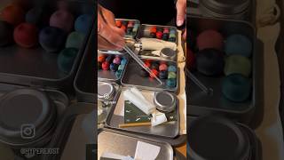 Sticking pebble paint on the tin. If the pebbles ever get loose, place a drop of water on the tin.